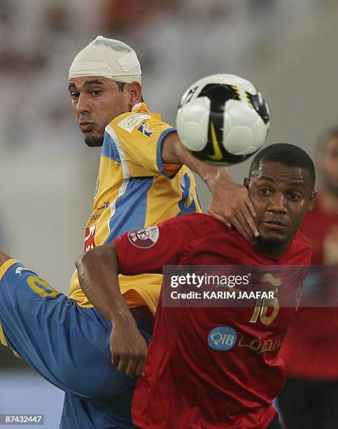 Al-Gharrafa's Yunes Mahmud of Iraq competes with Al-Rayyan's Omani player Hasan al-Mudhafar during their Emir Cup final football match in Doha, Qatar...