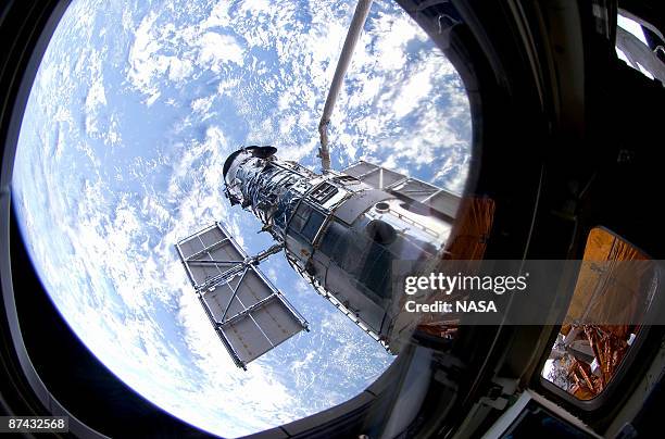 In this handout from NASA, the Hubble Space Telescope is grappled to Space Shuttle Atlantis STS-125 by the shuttle's Canadian-built remote...