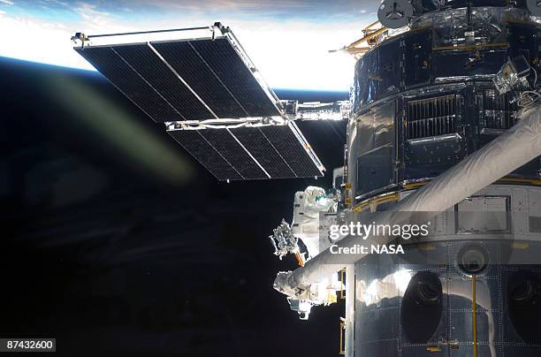 In this handout from NASA, Astronaut Andrew Feustel, perched alone on the end of the Space Shuttle Atlantis' remote manipulator system arm,...