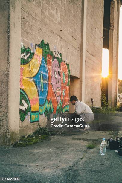 young man doing graffiti - grafitti artist stock pictures, royalty-free photos & images