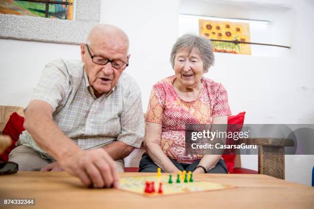 seniors playing ludo indoors - ludo stock pictures, royalty-free photos & images