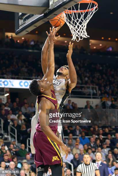 Providence Friars center Nate Watson shoots over Minnesota Golden Gophers forward Davonte Fitzgerald during a college basketball game between...