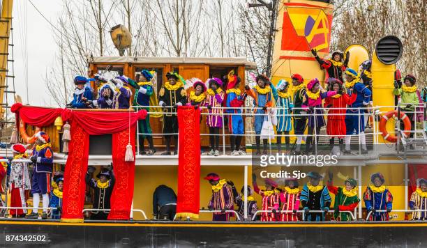 sinterklaas arriving by steam ship with his piet helpers - sinterklaas stock pictures, royalty-free photos & images