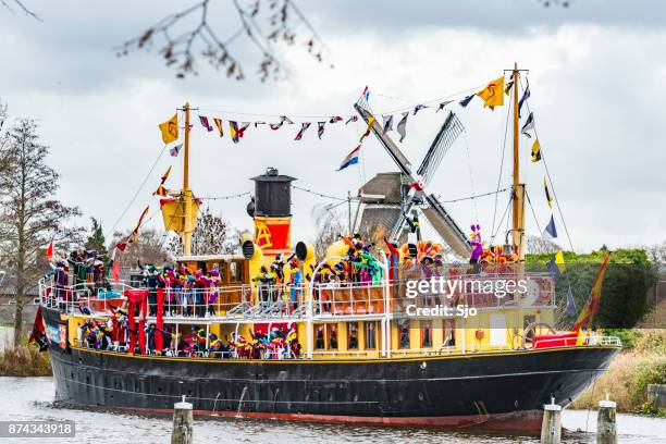 sinterklaas arriving by steam ship with his piet helpers - zwarte piet imagens e fotografias de stock