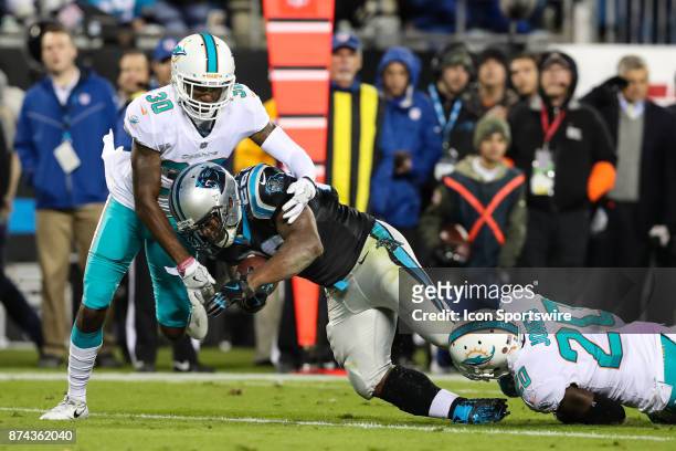 Carolina Panthers running back Jonathan Stewart is tackled by Miami Dolphins cornerback Cordrea Tankersley and free safety Reshad Jones during the...