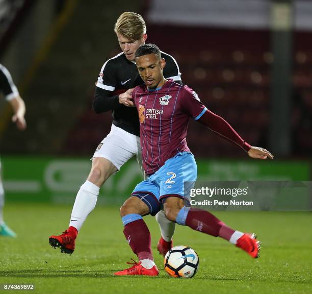 Jordan Clarke of Scunthorpe United plays the ball under pressure from George Smith of Northampton Town during the Emirates FA Cup First Round Replay...