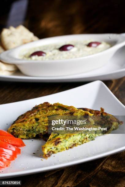 Front to back: Kuku Sabzi--Fresh herbs frittata with barberries and walnut and Salad Olivieh--Persian style chicken potato salad with peas and...