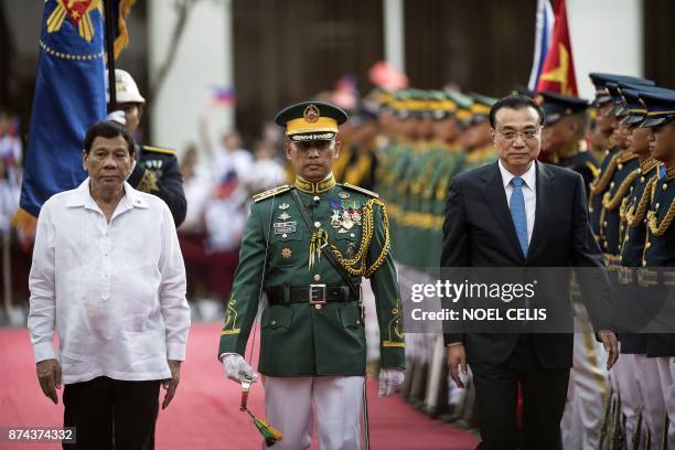 Philippines' President Rodrigo Duterte and China's Premier Li Keqiang inspect the honour guard during his official visit at the Malacanang palace in...