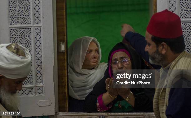 Kashmiri Muslim devotees pray at the shrine of the Sufi saint Sheikh Hamza Makhdoom during a festival on November 14, 2017 in Srinagar, the summer...