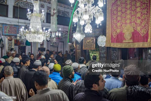 Kashmiri Muslim devotees pray at the shrine of the Sufi saint Sheikh Hamza Makhdoom during a festival on November 14, 2017 in Srinagar, the summer...