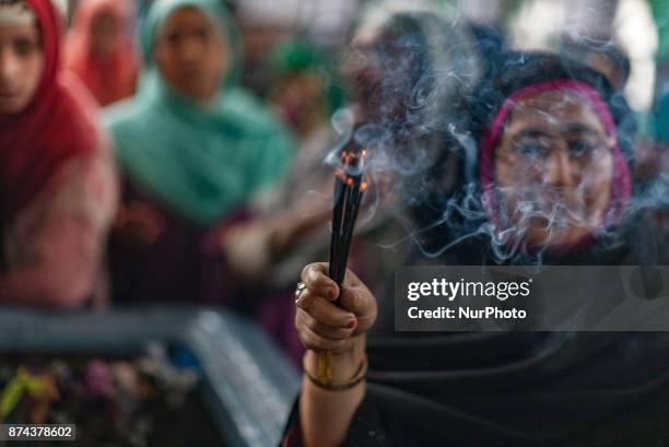 Kashmiri Muslim devotees pray at the shrine of the Sufi saint Sheikh Hamza Makhdoom during a festival on November 14, 2017 in Srinagar, the summer...