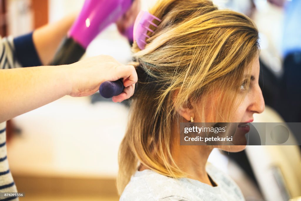 Friseurin mit Haarbürste und Haartrockner