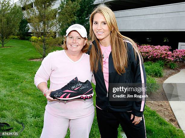 Tiffany Ortiz, wife of David Ortiz of the Boston Red Sox, presents drawing winner Teresa Paolini with a baseball shoe, formerly owned by David Ortiz...