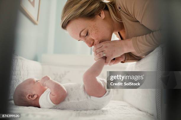 mother kissing her baby son - kissing feet stock pictures, royalty-free photos & images