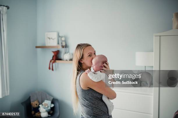 mother embracing her baby son - modern baby nursery stock pictures, royalty-free photos & images