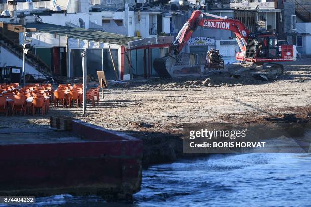 An excavator demolishes a restaurant that has been unrightfully erected on coastal terrain in Marseille, southern France, on November 15, 2017.