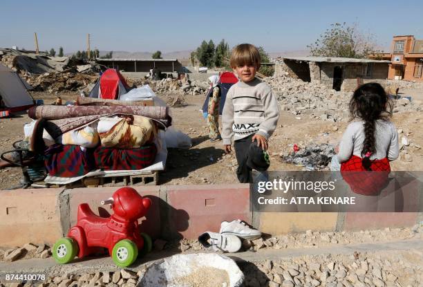 Picture taken on November 15, 2017 shows Iranians children next to the rubble of their home in Kouik village near to Sarpol-e Zahab, two days after a...