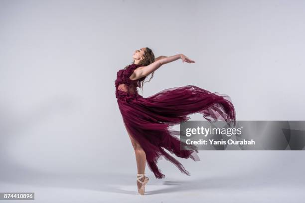 female ballet dancer dancing in studio - rode jurk stockfoto's en -beelden