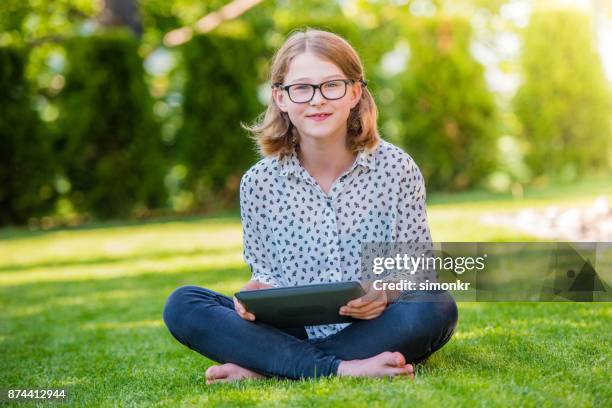 chica con tableta digital - girls barefoot in jeans fotografías e imágenes de stock