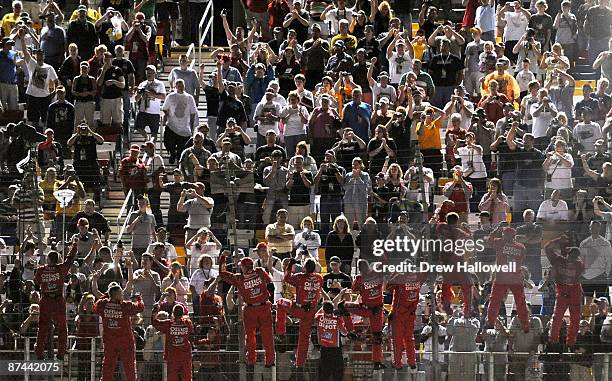 The Office Depot/Old Spice crew celebrates by climbing the fence in front of the fans after winning the NASCAR Sprint All-Star Race on May 16, 2009...