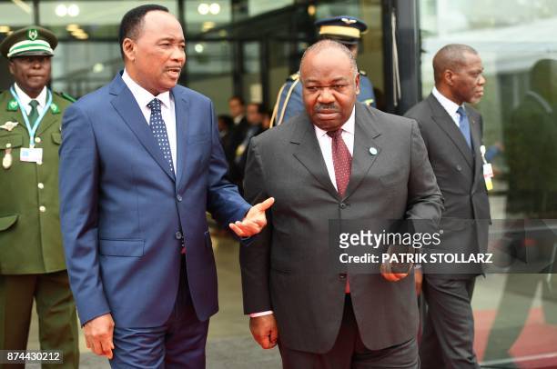 Ali Bongo Ondimba , President of Gabon, talks with Mahamadou Issoufou , President of Niger, as they arrive to attend a session of the UN conference...