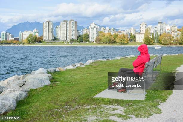 woman sits on the seashore - leren 個照片及圖片檔