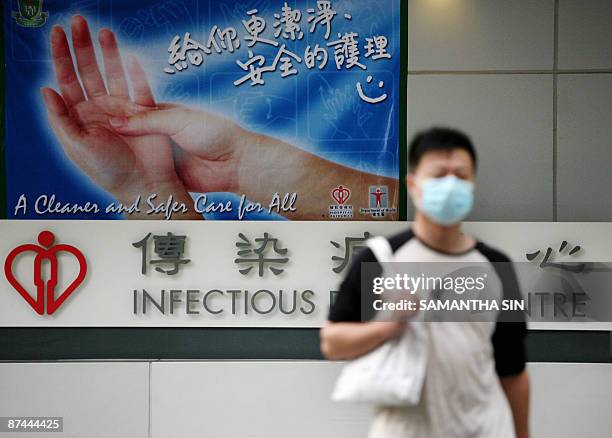 Pedestrian wears a mask as he walks past the the infectious disease centre at the Princess Margaret Hospital in Hong Kong on May 17, 2009. Hong Kong...