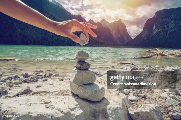 detail der person stapeln rocks by the lake - stone hand stock-fotos und bilder