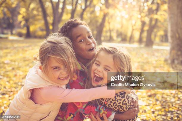 three little girls in park. - only girls stock pictures, royalty-free photos & images