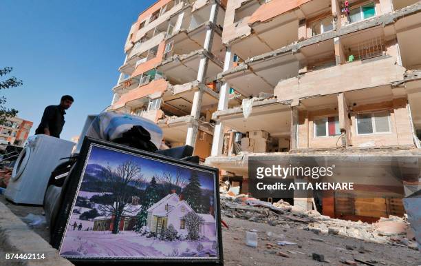 Iranians salvage their furniture and household appliances as they bring them outside the damaged buildings in the town of Sarpol-e Zahab in the...
