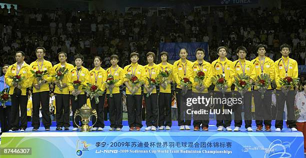 Members of China's badminton team observe Chinese national anthem on the podium at the Sudirman Cup world badminton championships at the Guangzhou...