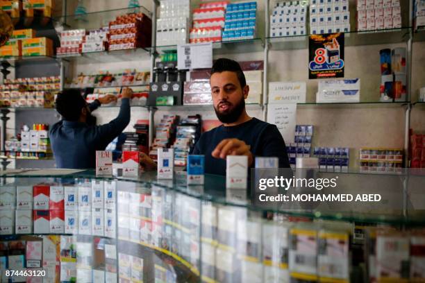 Palestinian vendors sell cigarettes at a shop in Gaza City on November 13, 2017. Under the deal agreed last month between Hamas and the Palestinian...