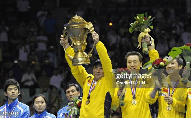 China's badminton team head coach Li Yongbo holds up the winning trophy on the podium at the Sudirman Cup world badminton championships at the...