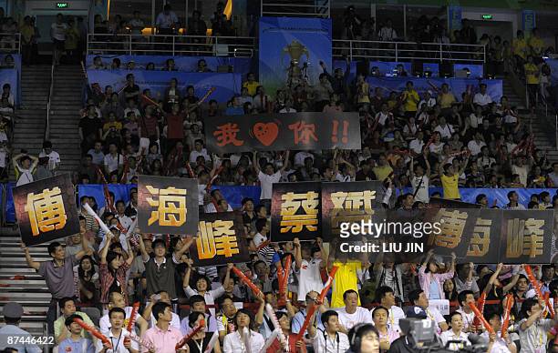 Chinese badminton fans show their support to China's players Cai Yun and Fu Haifeng during the men's doubles final match between China and South...