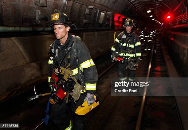 Emergency responders walk underground on the train tracks during an emergency drill staged near the World Trade Center site on May 17, 2009 in New...
