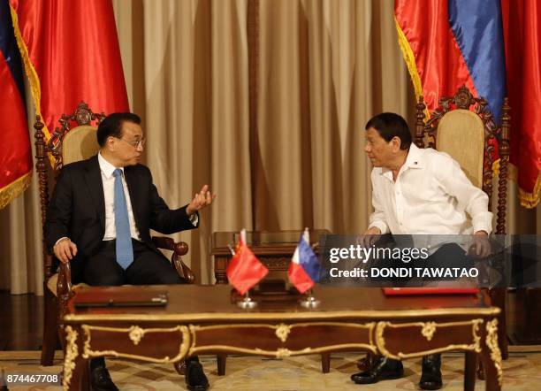 Philippines' President Rodrigo Duterte talks to China's Premier Li Keqiang during Li's one-day state visit at the Malacanang Palace in Manila on...