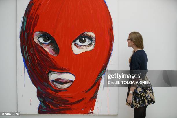 An assistant poses with 'Pussy Icons' artwork by contemporary artist Lusine Djanyan during a press preview for the 'Art Riot: Post-Soviet Actionism'...