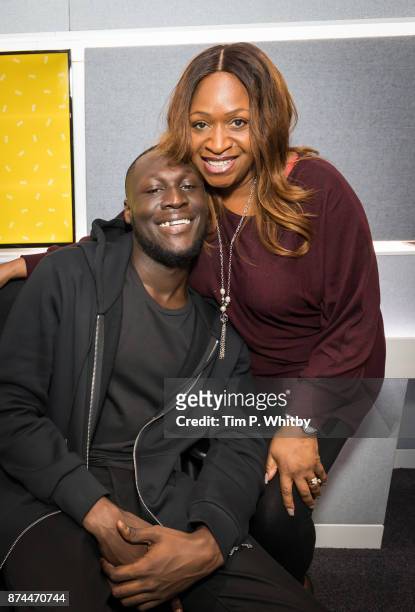 Stormzy poses for a photo with presenter Angie Greaves during a visit to the Magic FM Studio's on November 15, 2017 in London, England.