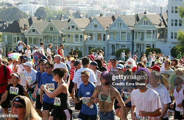 Participants run up Hayes Street Hill with the backdrop of the city's "Painted Ladies" houses during the ING Bay to Breakers race May 17, 2009 in San...