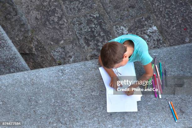 boy drawing outside - common aims stock-fotos und bilder