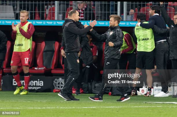Head coach Heiko Herrlich of Leverkusen gives co-coach Nico Schneck his hand during the Bundesliga match between Bayer 04 Leverkusen and 1. FC Koeln...
