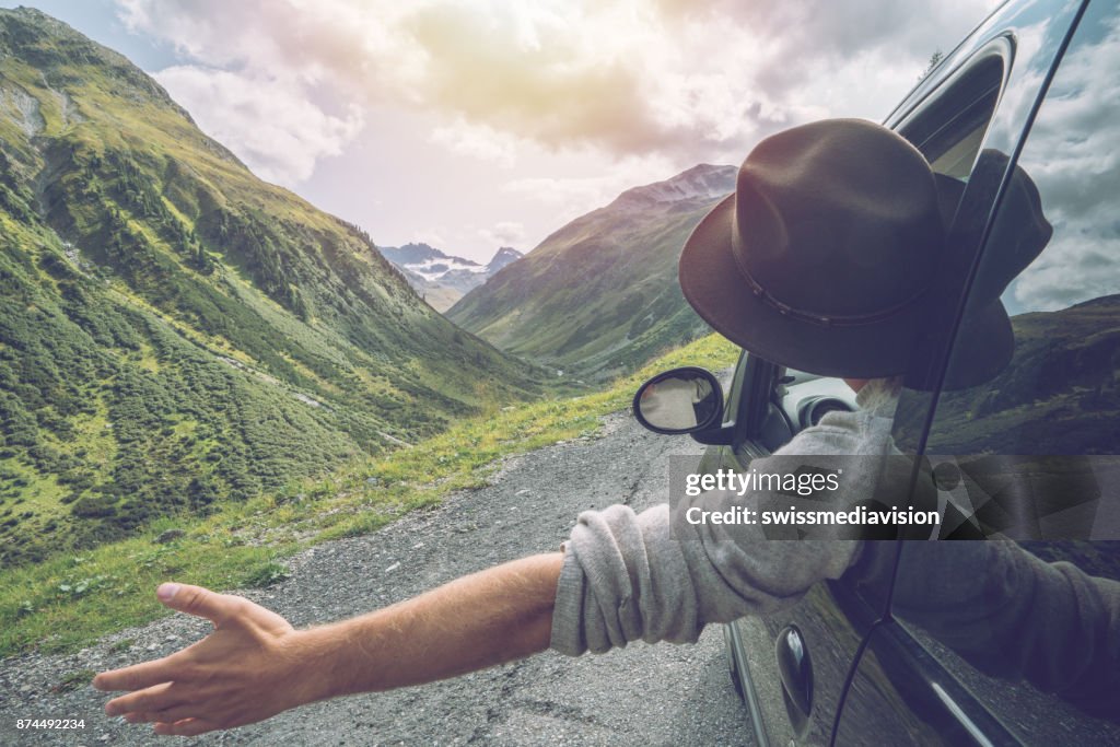 Caucasian male on road trip enjoying mountain landscape