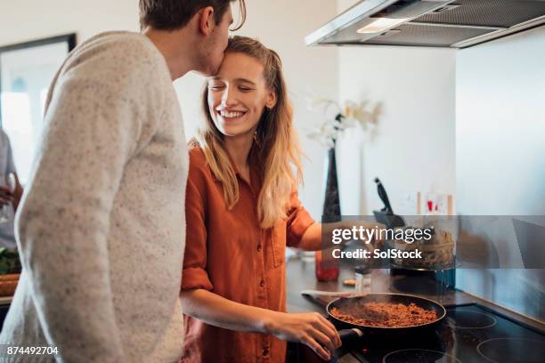 junges paar zu hause kochen - lasagne stock-fotos und bilder