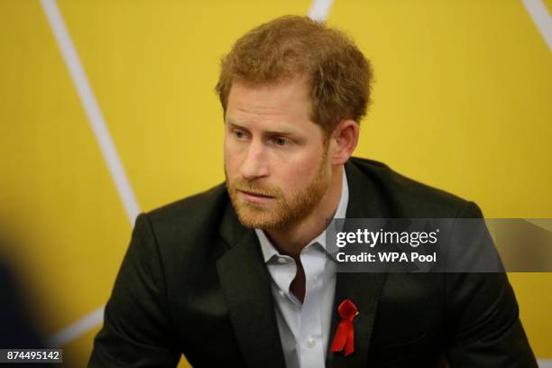 Prince Harry listens listens as Andrew Bates tells his story of his life after being diagnosed with HIV in 2015 during his visit to the opening of...