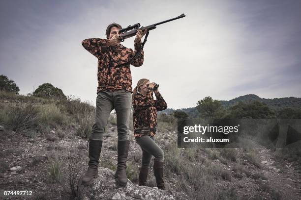 jagers man met geweer en vrouw met een verrekijker in spanje - jachtgeweer stockfoto's en -beelden