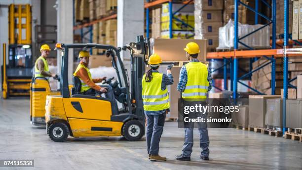 arbeiter im lager arbeiten - gabelstapler stock-fotos und bilder