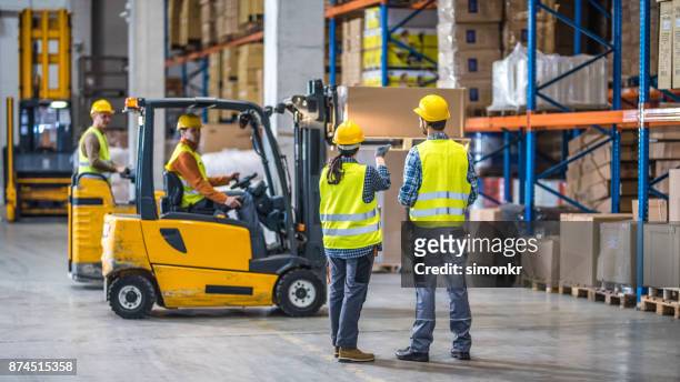 arbeiders werken in magazijn - freight transportation stockfoto's en -beelden