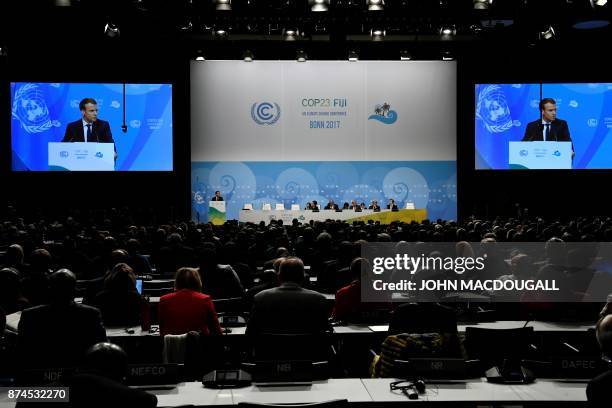 French President Emmanuel Macron is seen on giant screens as he speaks during the UN conference on climate change on November 15, 2017 in Bonn,...