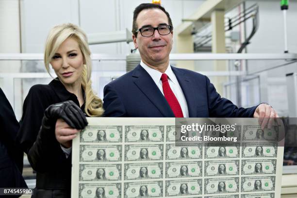 Steven Mnuchin, U.S. Treasury secretary, right, and his wife Louise Linton hold a 2017 50 subject uncut sheet of $1 dollar notes bearing Mnuchin's...