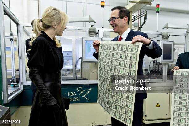 Steven Mnuchin, U.S. Treasury secretary, right, displays a 2017 50 subject uncut sheet of $1 dollar notes bearing Mnuchin's name for his wife Louise...